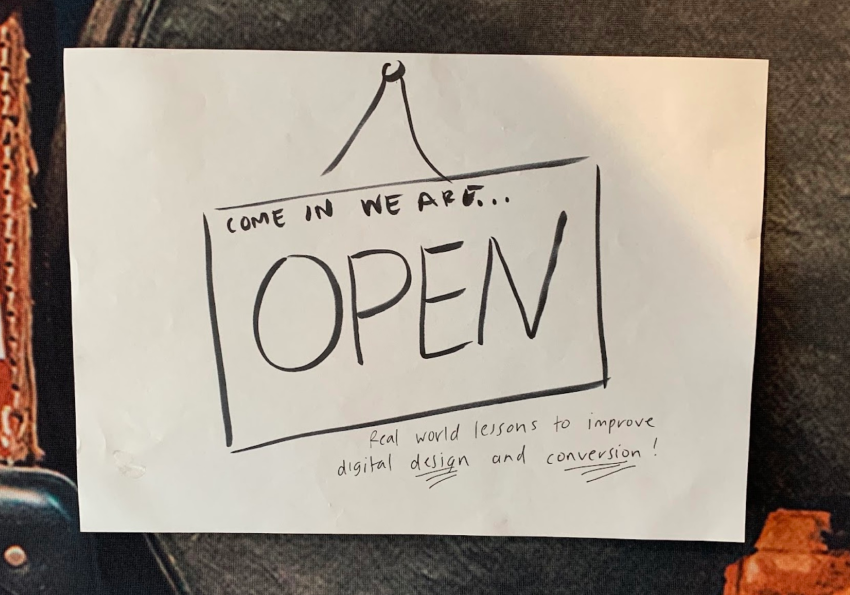 A handwritten piece of paper that says, "Come in, we're open"